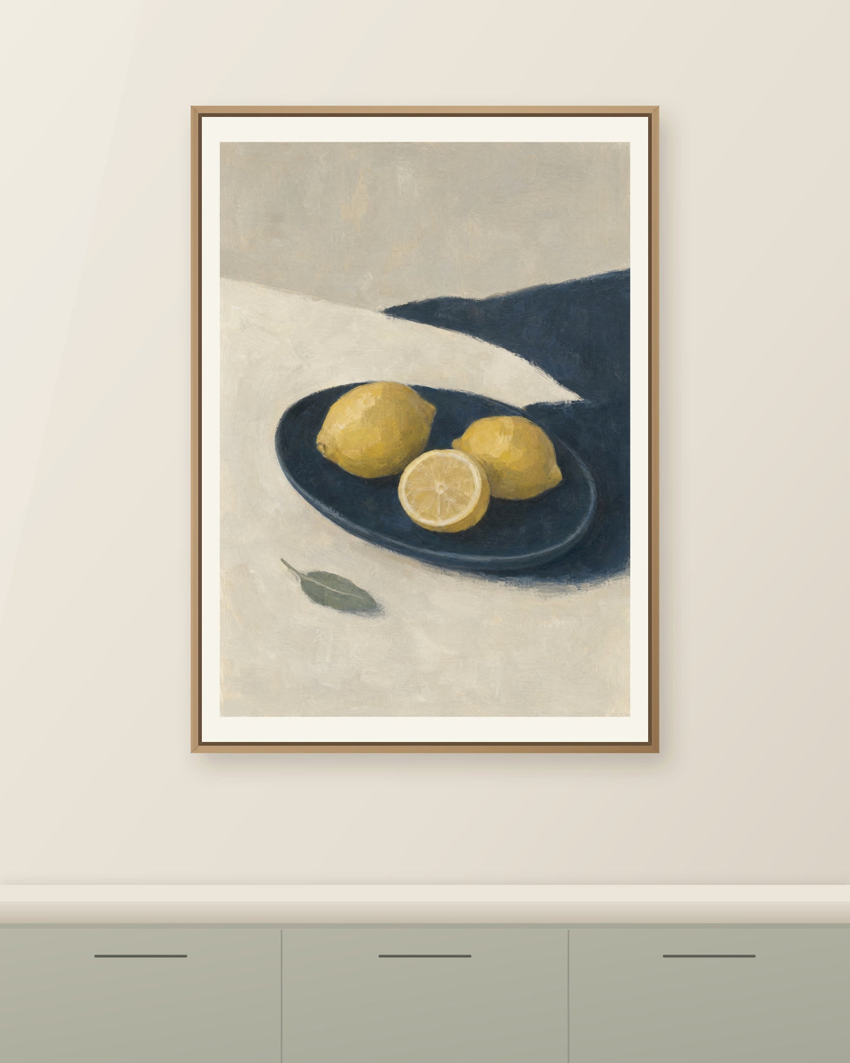 Gula citroner och en citronhalva i ett mörkblått fat på en ljus yta, målade med synliga penseldrag. Illustrerad inramningsvy. Ram ingår inte.